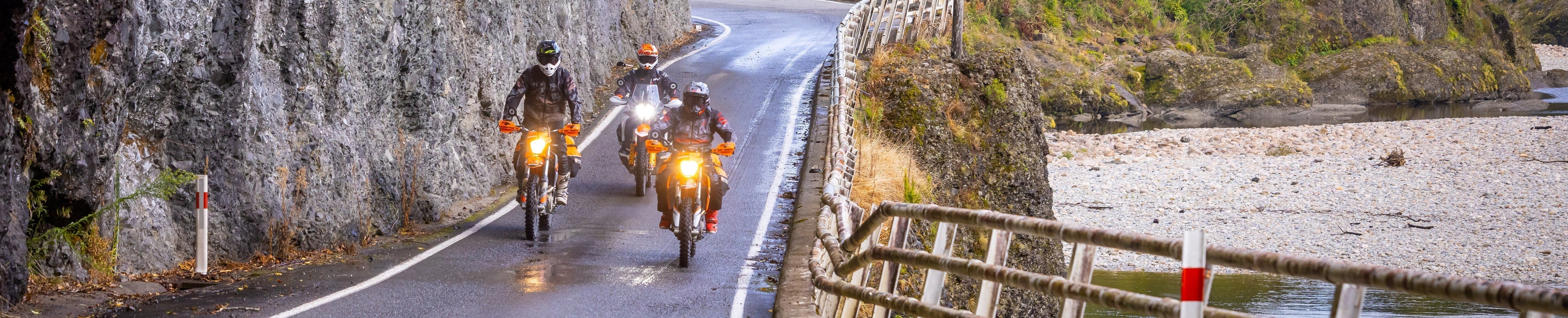Three motorcyclists riding on a wet road. Photography credit @cudby for Cardo