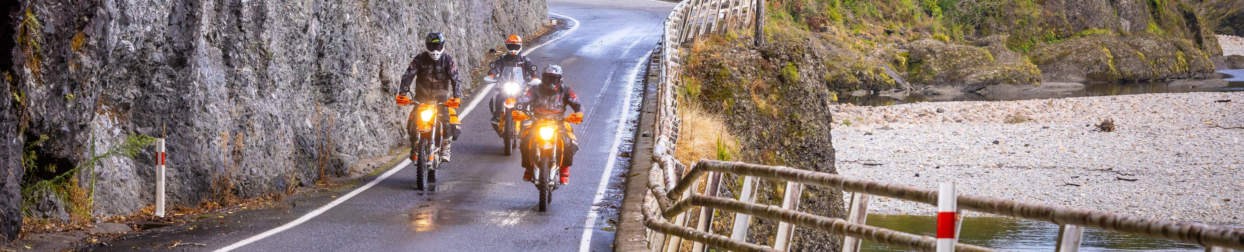 Three motorcyclists riding on a wet road. Photography credit @cudby for Cardo